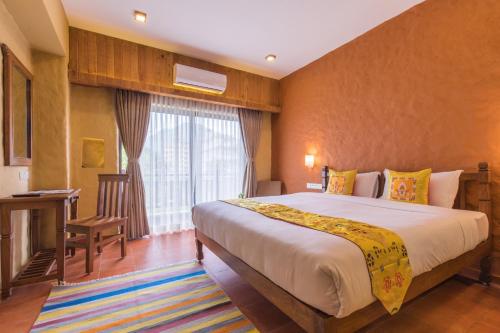 a hotel room with a large bed and a window at Hotel Mala Pokhara in Pokhara