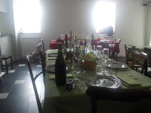Ca' Do Diao في Onzo: طاولة مع قطعة قماش وطاولة خضراء وكؤوس للنبيذ
