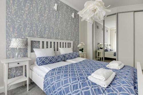 a bedroom with a blue and white bed and a mirror at Lion Apartments - Parkowa 33Am2 z parkingiem 2 min od plaży in Sopot