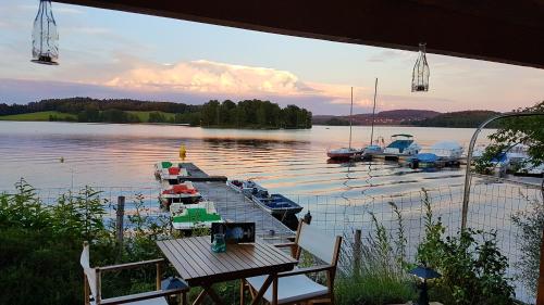a view of a dock with boats in the water at Hotel Restaurant La Caravelle in Peyrat-le-Château