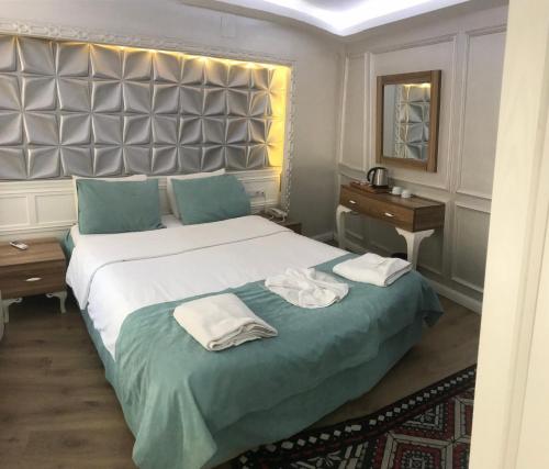 a bedroom with a large bed with towels on it at Hotel Grand Heykel in Bursa