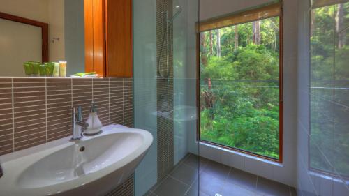 a bathroom with a sink and a large window at Montville Ocean View Cottages in Montville