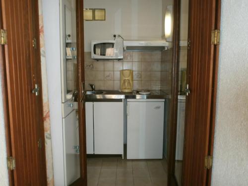 une petite cuisine avec un évier et un micro-ondes dans l'établissement Studio n°2 avec terrasse, agréable, bien situé, à Amélie-les-Bains-Palalda