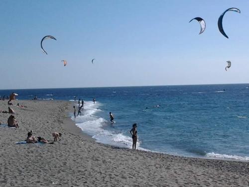 a group of people on a beach flying kites at Guest Room Nesea in Pellaro