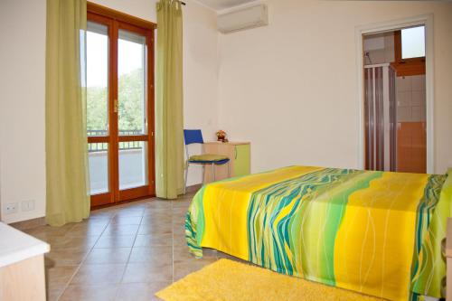 a bedroom with a colorful bed and a balcony at B&B Iside in Montepaone