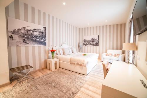 ein Schlafzimmer mit einem weißen Bett und gestreiften Wänden in der Unterkunft Rooms Milano Duomo in Mailand
