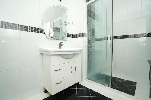 uma casa de banho branca com um lavatório e um chuveiro em SUPER OYO 782 Menjangan Residence at Citraland 1 em Lontar