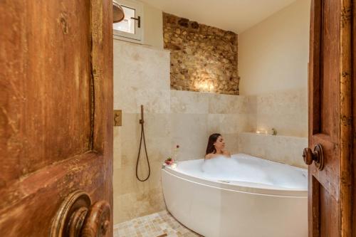 a white bath tub sitting next to a bath tub at Villa I Barronci Resort & Spa in San Casciano in Val di Pesa
