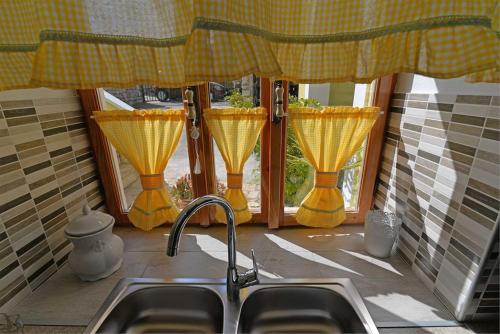 a kitchen with a sink and a window with curtains at Roberto 4 in Veli Lošinj