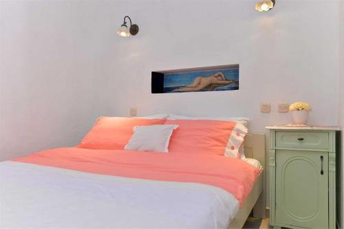 a bedroom with a bed with orange sheets and a table at Roberto 4 in Veli Lošinj