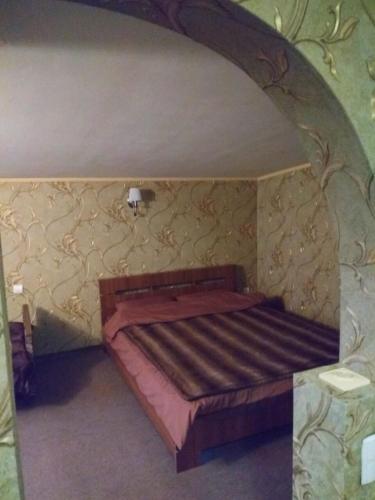 a small bed in a room with a wall at Khorol-1 Motel in Khorol
