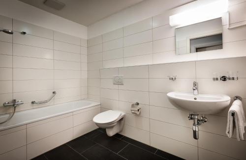 a white bathroom with a sink and a toilet at Residenze dell'Angelo in Locarno