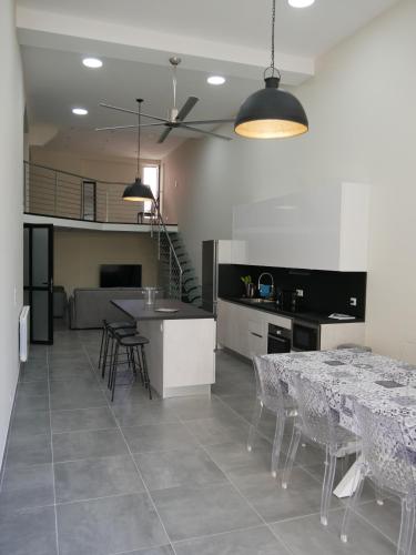 une cuisine et une salle à manger avec une table et des chaises dans l'établissement GRAND LOFT chic et moderne, déco industrielle, à Beausoleil