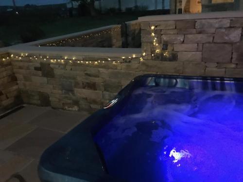 a jacuzzi tub in a backyard with lights at Salt Pot Cottage in Skipton