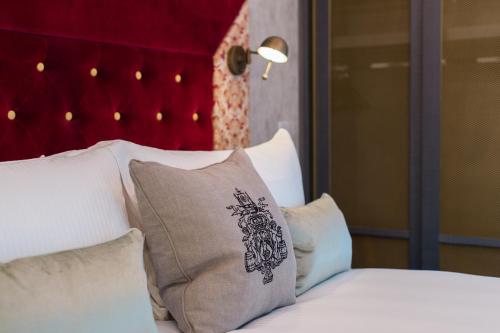 a bed with white pillows and a red headboard at Vintry & Mercer in London