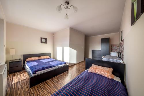a bedroom with two beds in it with a blue blanket at Willa Sarbinowo in Sarbinowo