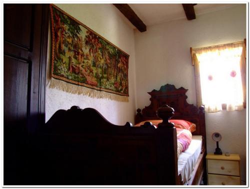 a bedroom with a bed and a painting on the wall at Tradicije Cigoc in Čigoč