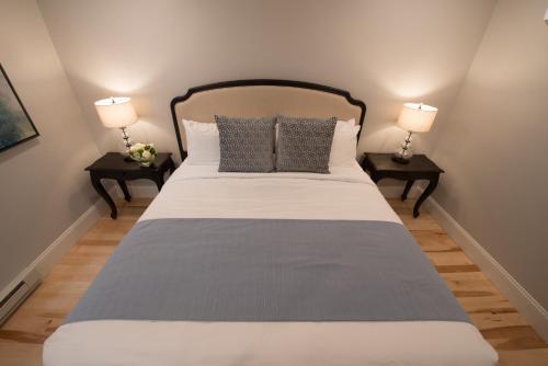 a bedroom with a bed with two lamps on two tables at The Outlook Inn in Newport
