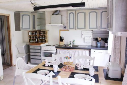 a kitchen with a table and chairs in a kitchen at Schwedenhaus Lillkvist in Uddeholm