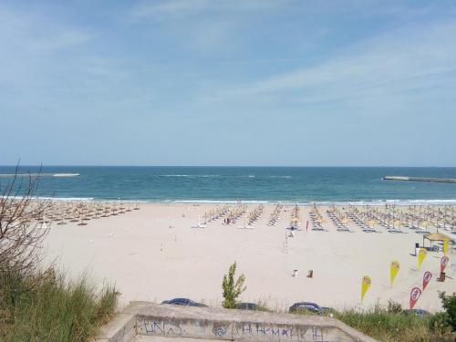 コンスタンツァにあるApartament Georgeの海の景色を望むビーチ(椅子、パラソル付)