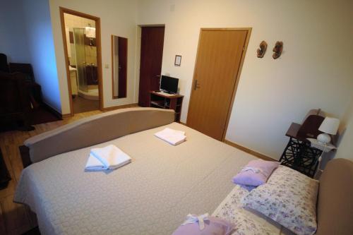 a bedroom with a bed with two towels on it at Apartments Cvelic Milovcic in Malinska