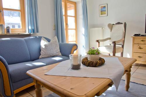 a living room with a table and a blue couch at Ferienwohnungen Budererhof in Bad Wiessee