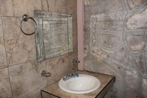 y baño con lavabo y espejo. en Cabañas Margarito, en Areponapuchi