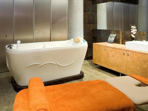 a bathroom with a bath tub and a sink at Tallink Spa & Conference Hotel in Tallinn