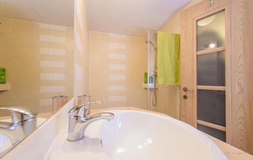 baño con lavabo blanco y toalla verde en Mango Rooms, en Brasov