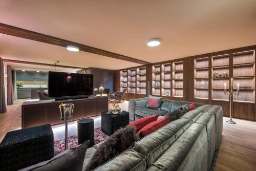 a living room with a couch and a flat screen tv at Nidus Luxury Apartments in Lech am Arlberg