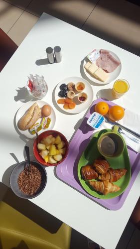 a table with various breakfast foods on it at ibis Styles Bordeaux Aéroport in Mérignac