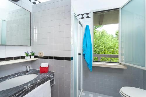 a bathroom with a sink and a blue umbrella at Residenza Villa Lidia in Riccione