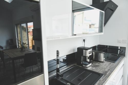 a kitchen with a sink and a dining table at BodyGo Penthouse in Capbreton