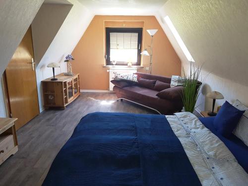 uma sala de estar com uma cama e um sofá em Montanregion Erzgebirge-Ihr Urlaub ist unsere Herzenssache em Langenberg