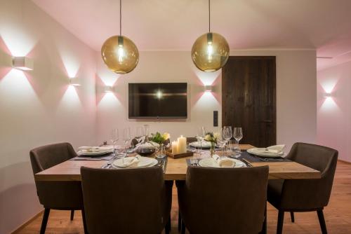 a dining room with a table and chairs and lights at Nidus Luxury Apartments in Lech am Arlberg