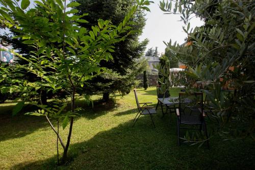 a garden with a table and chairs and trees at Apartman Ana 2 in Trebinje