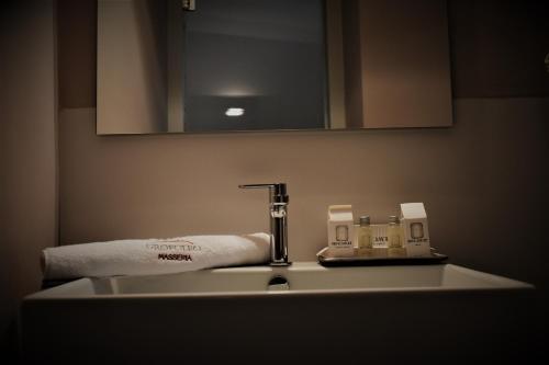 a bathroom sink with a faucet and a mirror at Masseria Grofoleo in Locorotondo