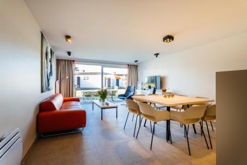 uma sala de jantar e sala de estar com mesa e cadeiras em Holiday Home Jonckershof em Middelkerke