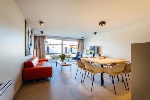 ミッデルケルケにあるHoliday Home Jonckershofのテーブルと椅子のあるダイニングルームとリビングルーム