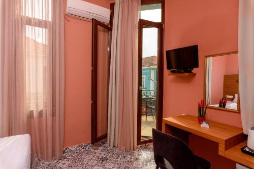 Habitación de hotel con cama, escritorio y espejo. en TheJoy, en La Canea