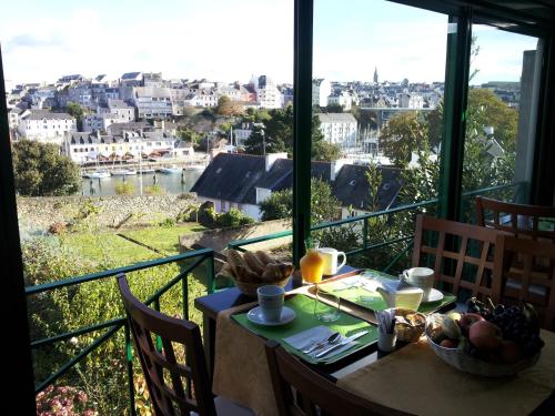 una mesa con vistas a la ciudad desde el balcón en Cit'Hotel Du Port Rhu, en Douarnenez