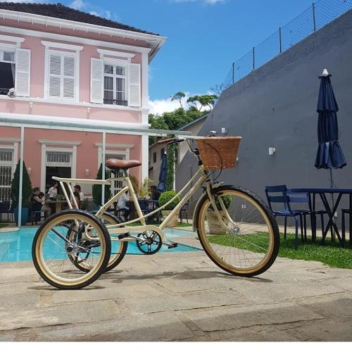 a bike parked next to a house and an umbrella at Casa Rosa Hotel Boutique in Petrópolis