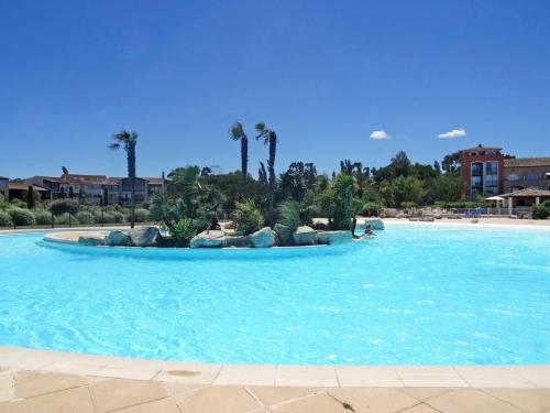 a large pool with blue water and palm trees at Green Suite Golfe de Saint Tropez in Gassin