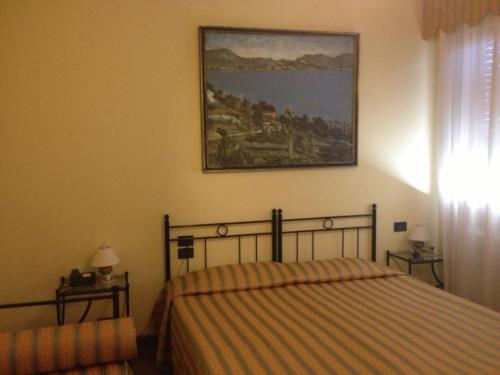 ヴェネツィアにあるゲストハウス　アロッギ　アグリ　アルティスティのベッドルーム1室(ベッド1台付)が備わります。壁には絵画が飾られています。