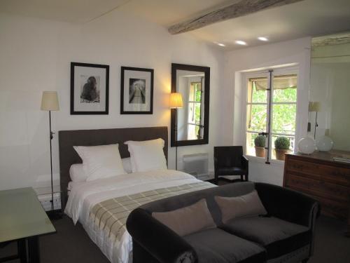 1 dormitorio con cama, sofá y ventanas en Appartement Cours Mirabeau CrsMb, en Aix-en-Provence