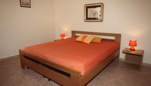 a bedroom with a bed with two lamps on it at Melograno in San Vito lo Capo