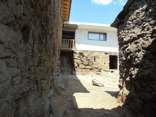 an alley between two stone walls with a building at Casa D'o Canto in Vinhais