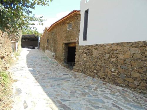 an alley with a stone wall and a building at Casa D'o Canto in Vinhais