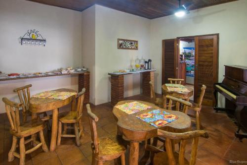 a room with tables and chairs and a piano at Pousada Acquarela in Paraty