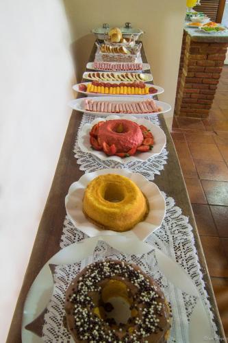 a row of donuts on plates on a table at Pousada Acquarela in Paraty